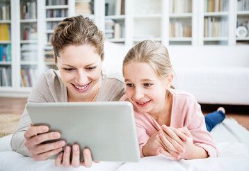 Mutter und Tochter nutzen Tablet zu Hause
