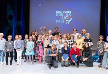 Kinder und Erwachsene auf der Bühne bei der Verleihung des deutschen Kinderbuchpreises