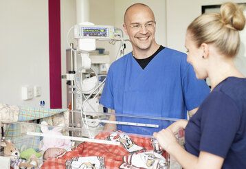 Dr. med. Martin Berghäuser, Chefarzt der Klinik für Kinderheilkunde mit einer Mutter auf der Kinderintensivstation im Florence-Nightingale-Krankenhaus